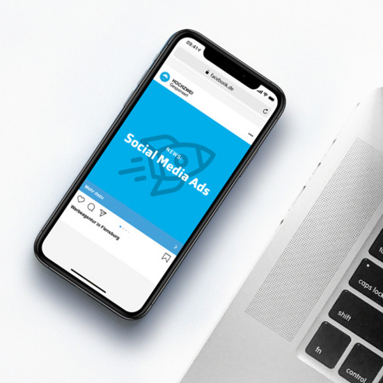 Neue Regelung für Bildtext bei Facebook-Ads Smartphone mit blauer Hochzwei Kachel