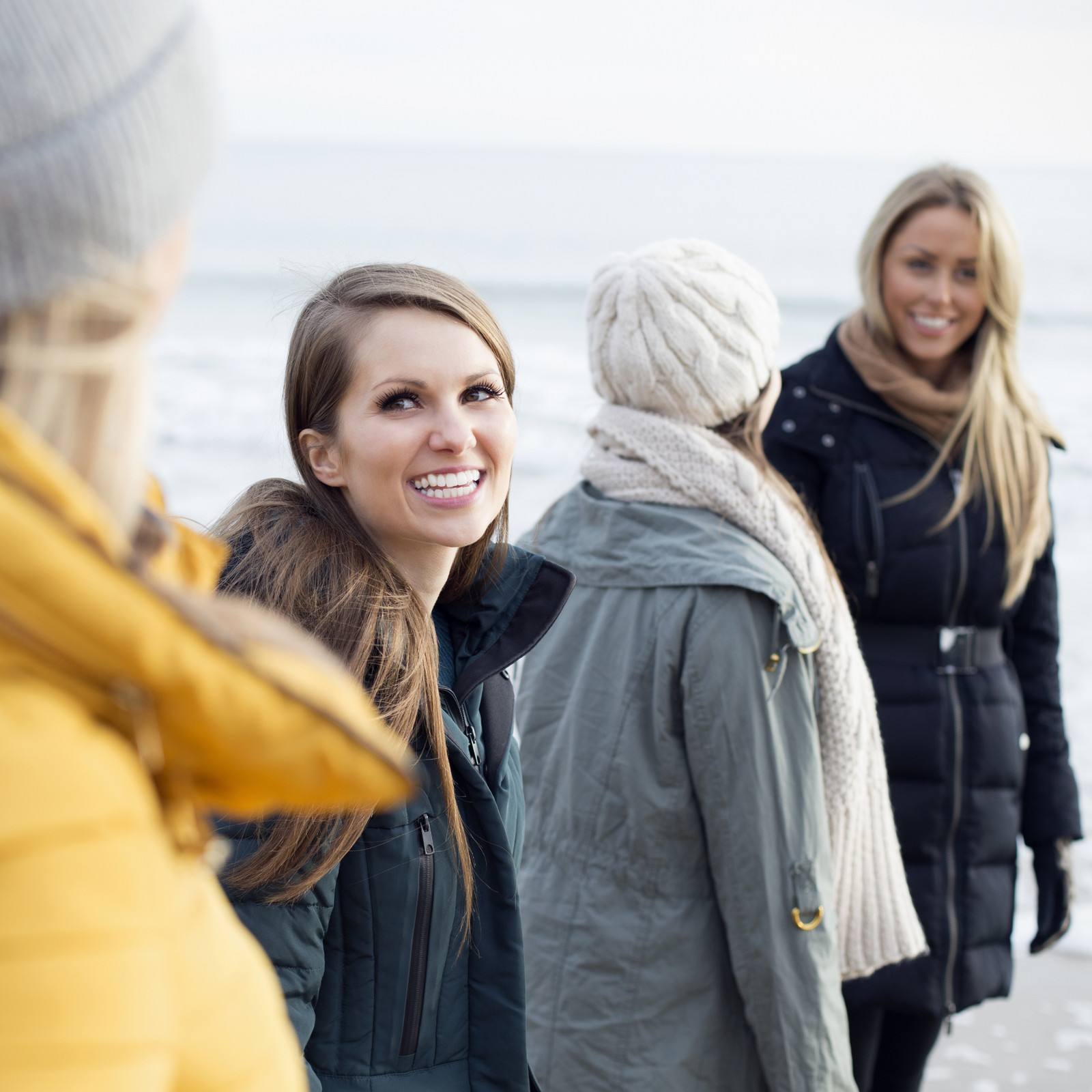 hochzwei_tsw_teaser_08.jpg Drei Frauen stehen am Strand und lächeln sich gegenseitig an