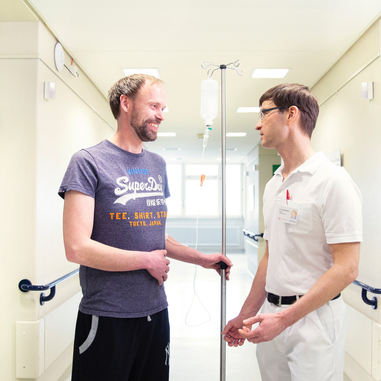 hochzwei_malt_teaser_09.jpg Arzt berät Patienten im Flur