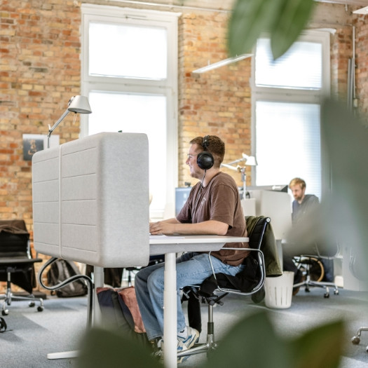 h2_einblicke-arbeitgeber_teaser_08.jpg Mitarbeiter arbeitet konzentriert mit Kopfhörern