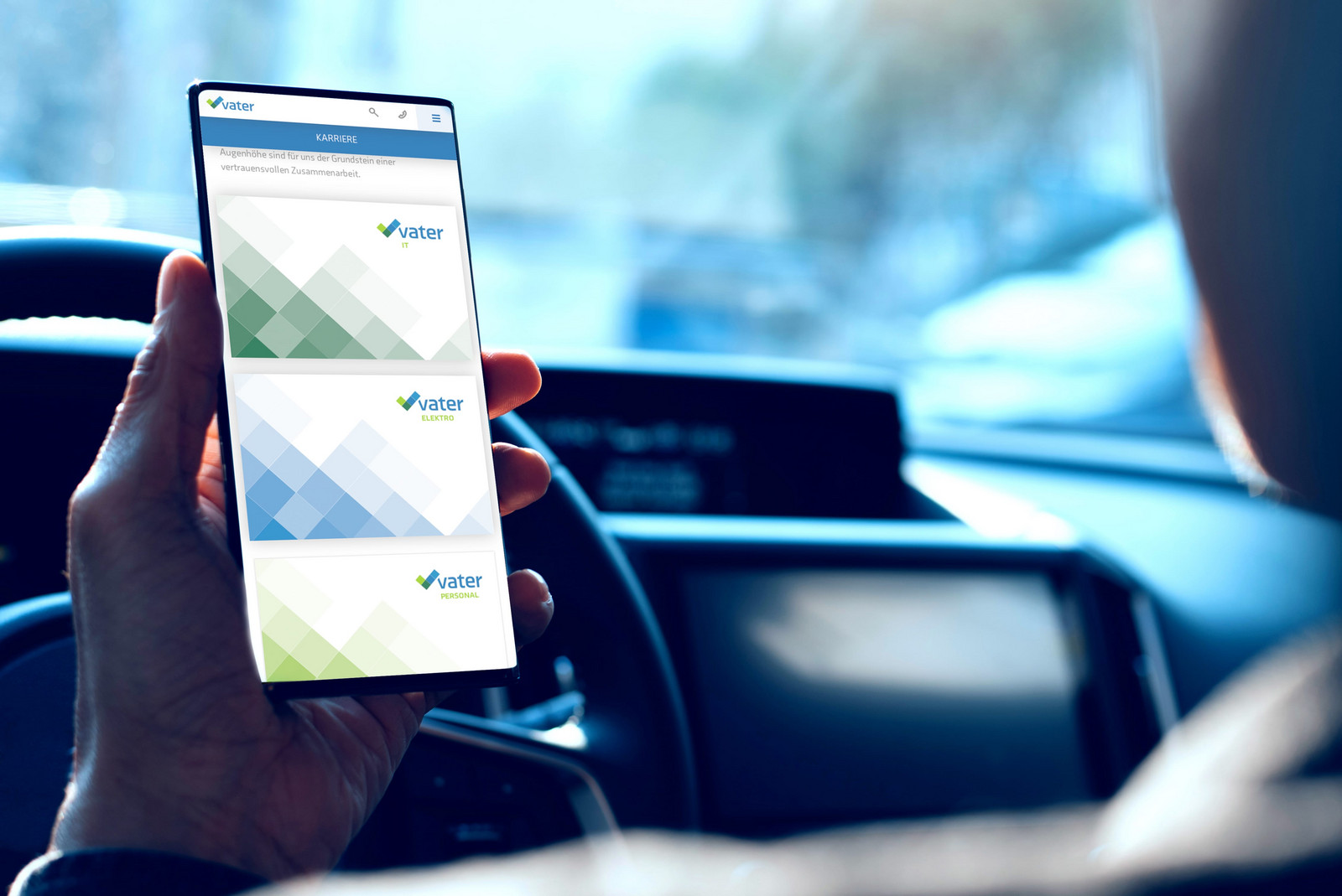 Person hält Handy im Auto