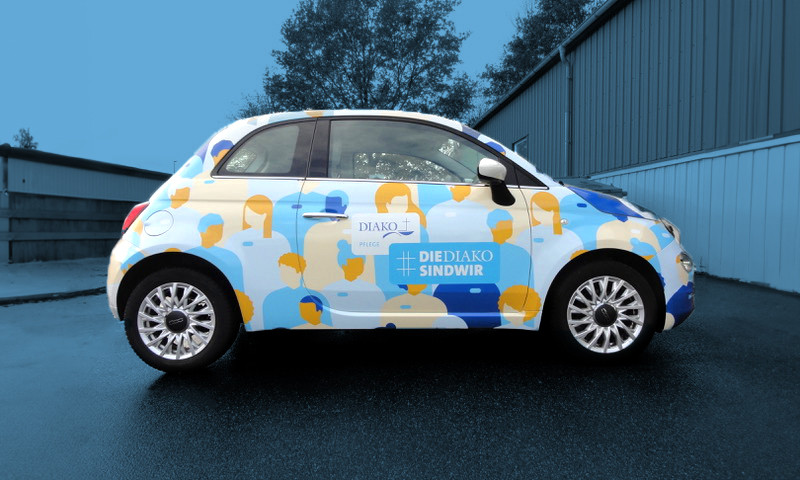 h2_diako_recruiting_teaser_10jpg.jpg Weißer Pkw bedruckt mit Diako-Logo und buntem Kampagnenmotiv