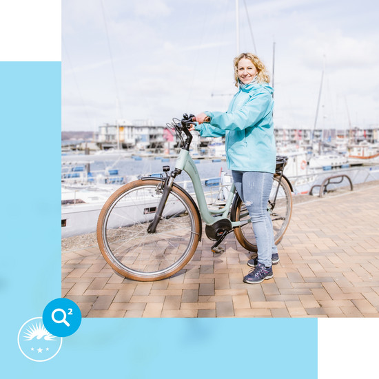 Energiesparen im Agenturalltag Mitarbeiterin fährt mit dem Fahrrad zur Arbeit