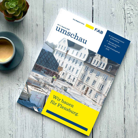 Auf Holztisch liegendes FAB-Magazin mit Titelblatt "Wir bauen für Flensburg"