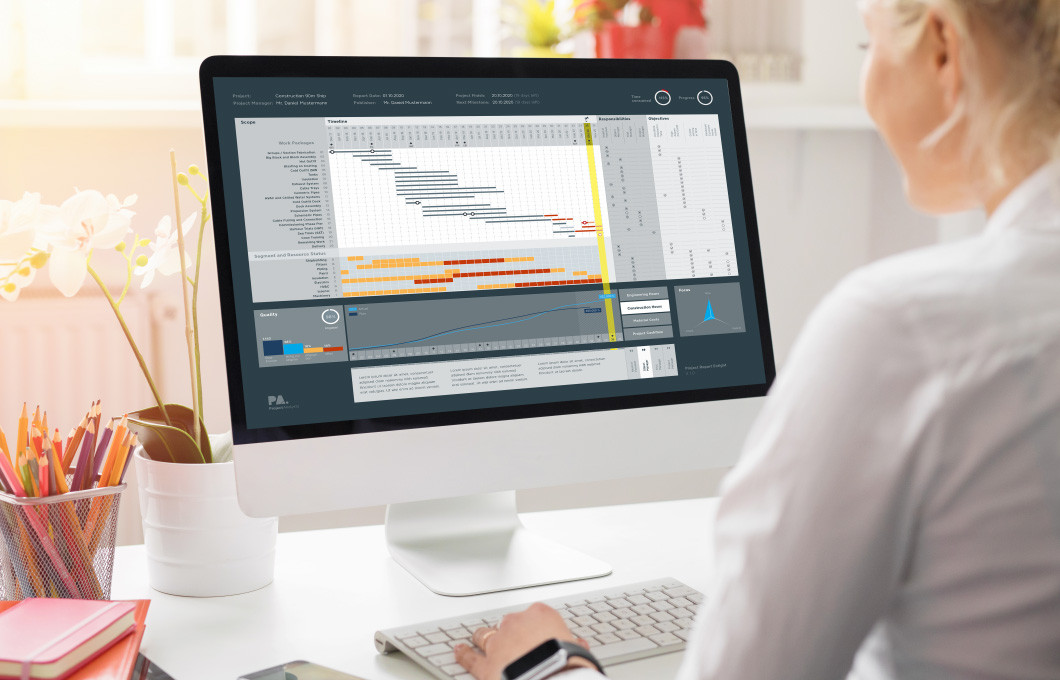 projectanalysts-10.jpg Blonde Frau sitzt am Schreibtisch