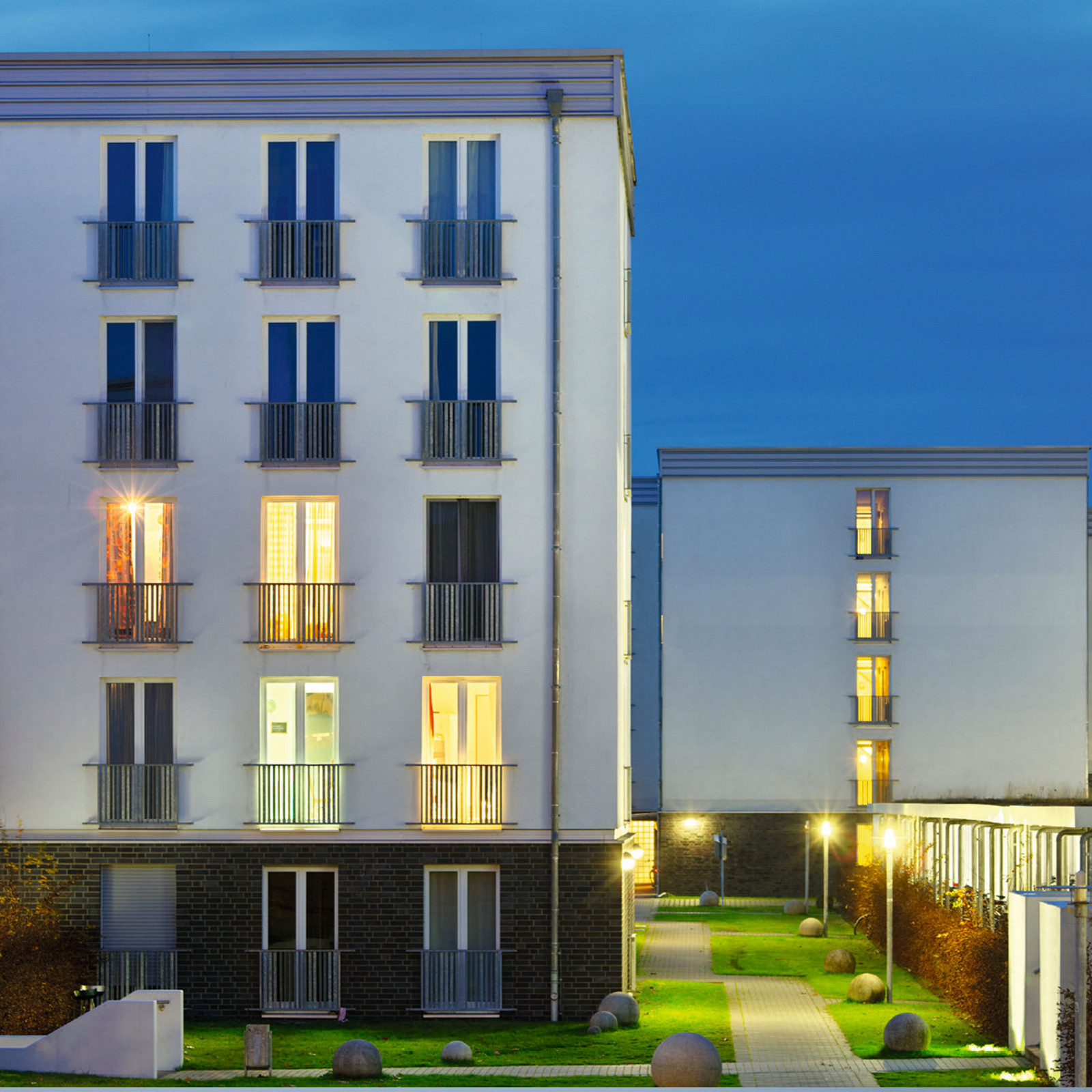 hochzwei_smartlodge_teaser_03.jpg Weißes Gebäudekompleks mit Fensterfront