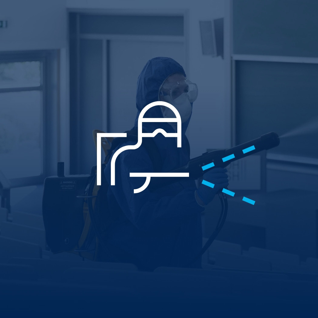 Ein Mann desinfiziert einen Hörsaal