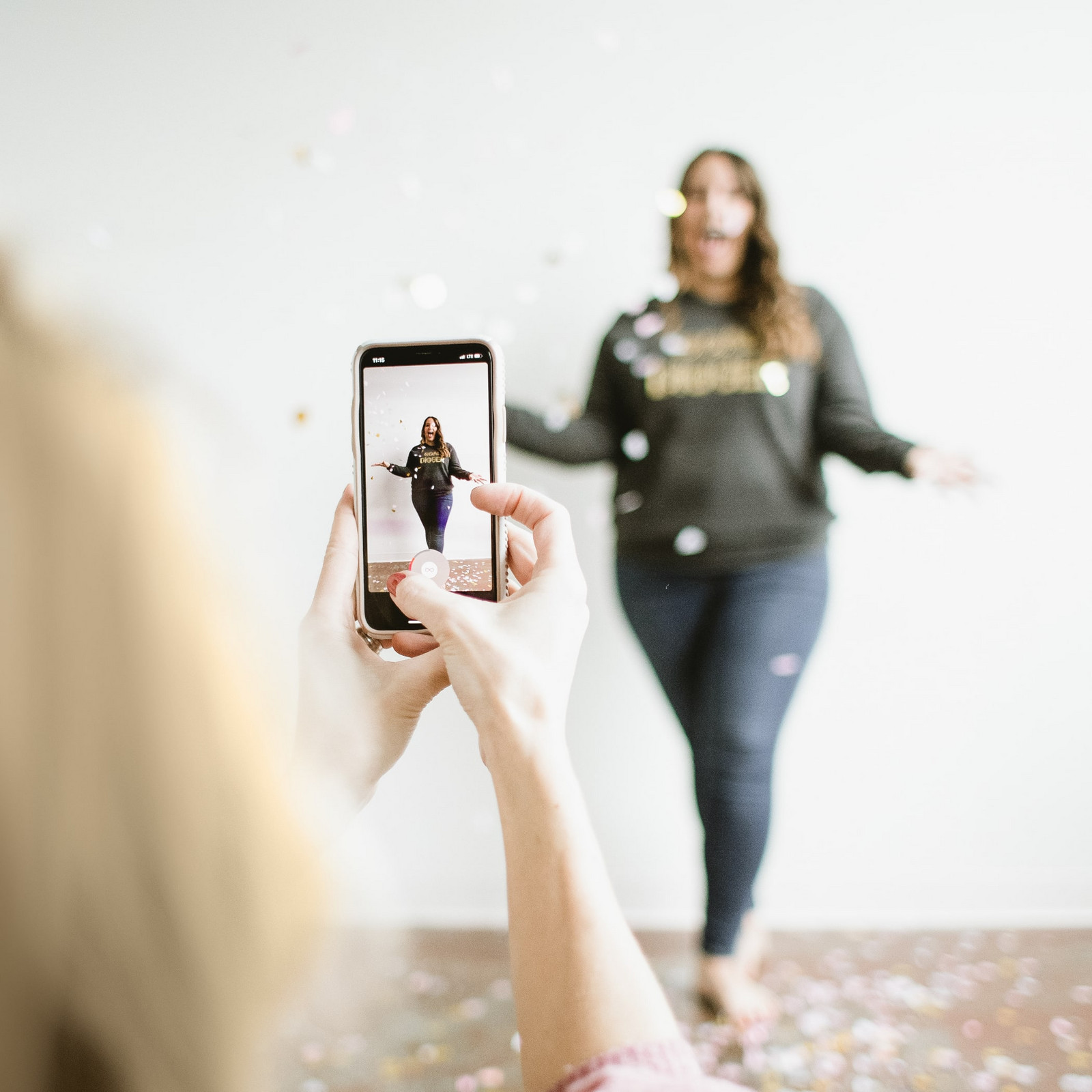 Eine Person fotografiert eine Frau mit Konfetti