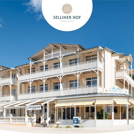 Ansicht des Selliner Hofes von der Straße bei Sonnenschein und wolkenlosem Himmel. Das Gebäude hat auf jeder Etage überdachte Balkone.