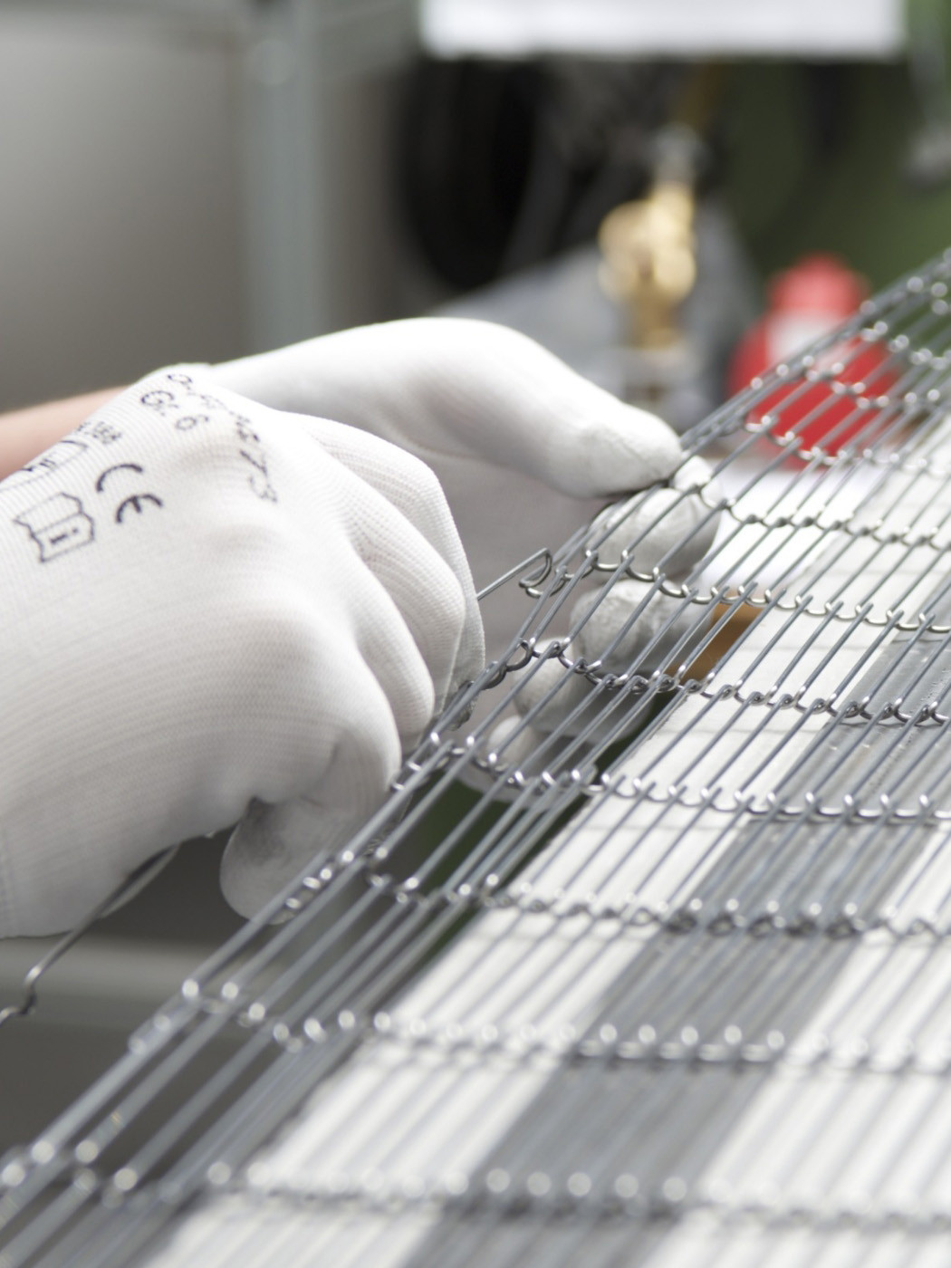 hochzwei_MRT_teaser_10.jpg Eine Hand arbeitet an einem metallischen Transportband