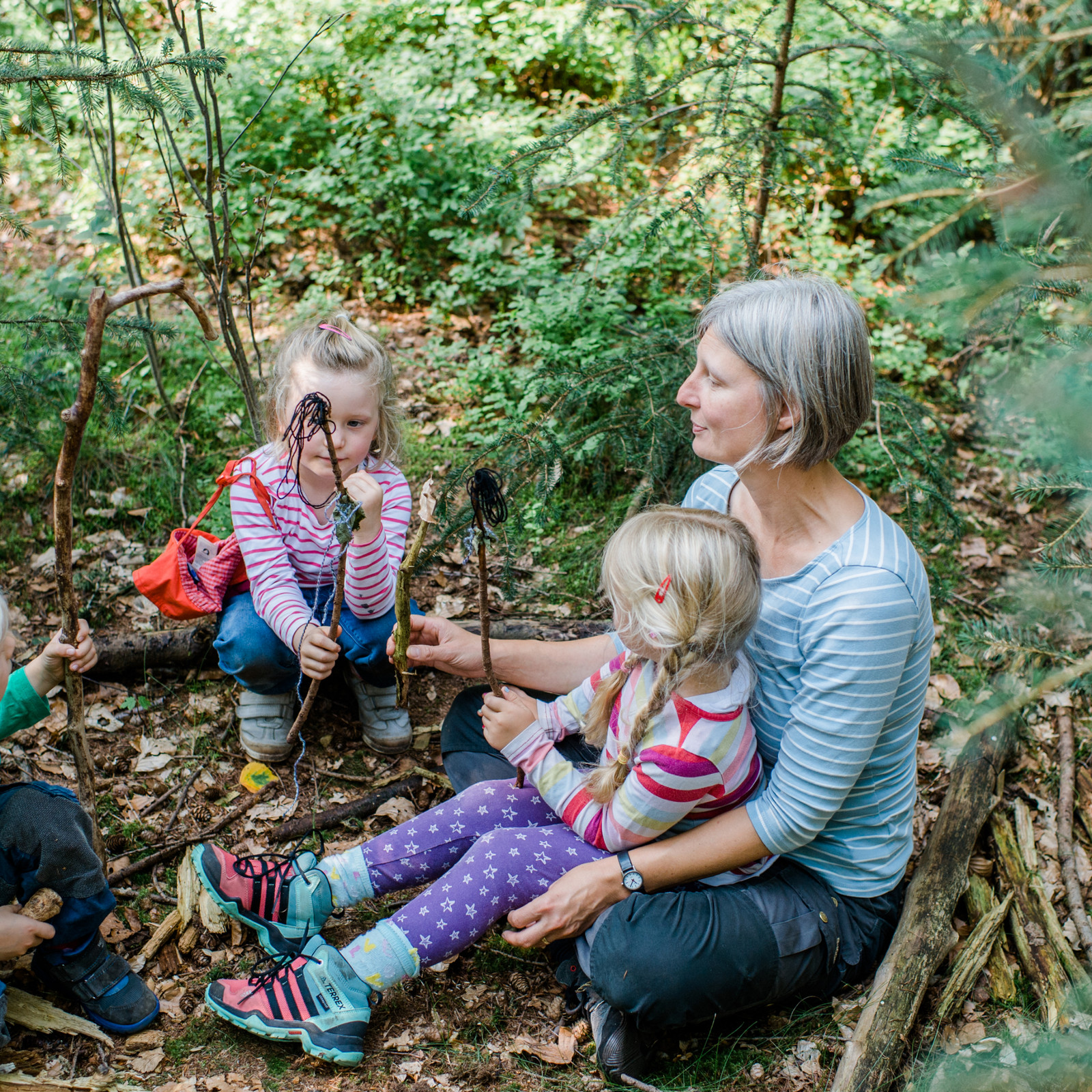 hochzwei_gewa_teaser_07.jpg Eine Kindergärtnerin ist im Wald mit zwei Mädchen