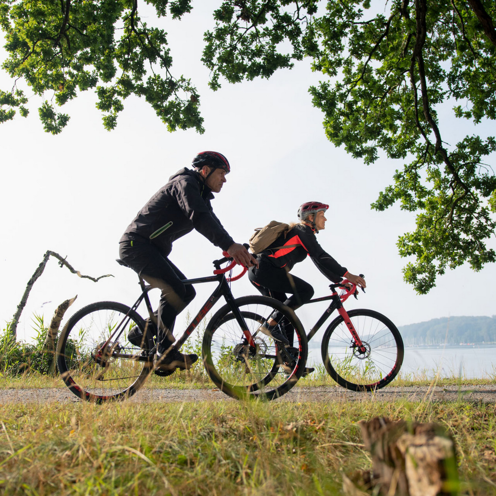 hochzwei_flfj_teaser_10.jpg Zwei Personen fahren Fahrrad am Wasser