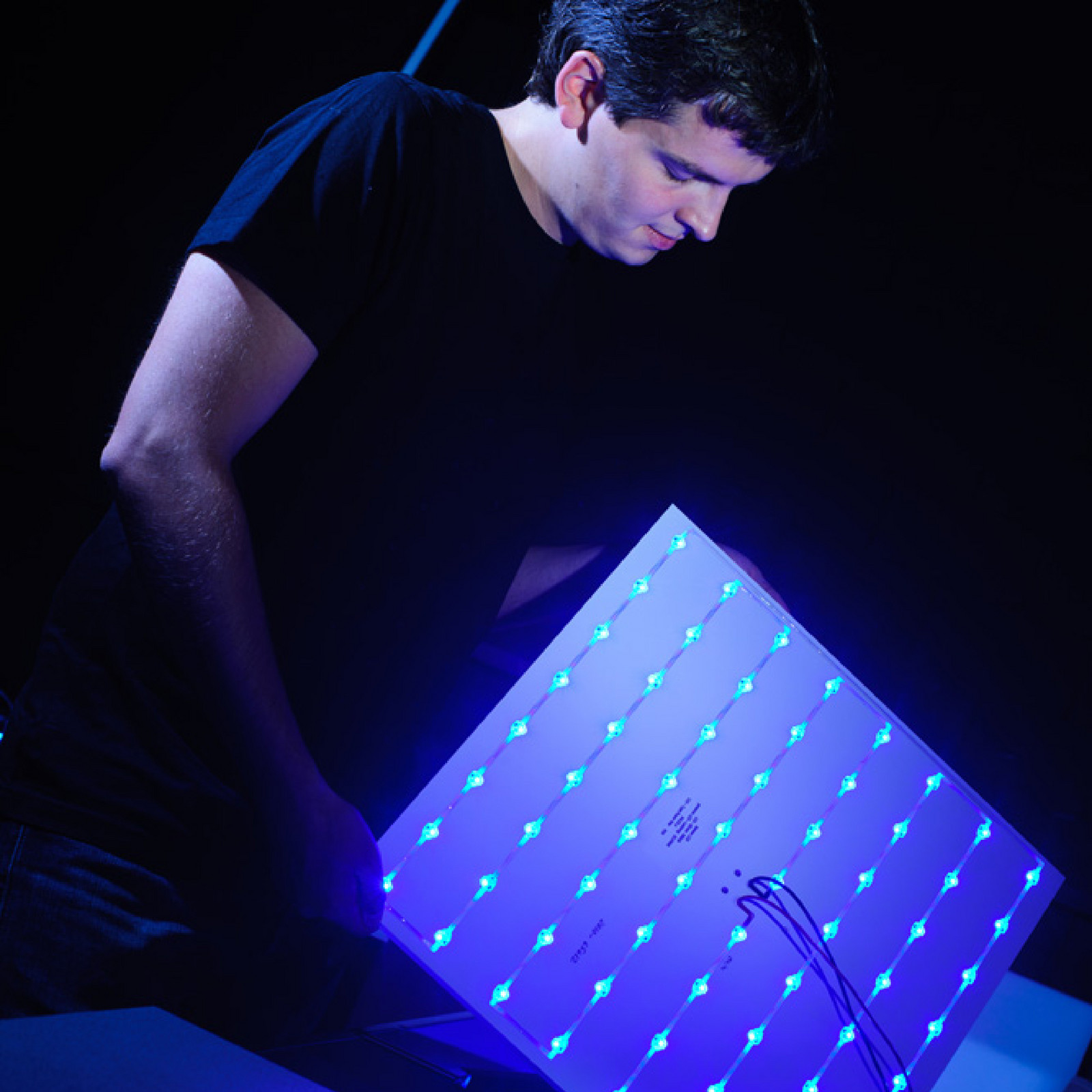 hochzwei_hansenneon_teaser_01.jpg Ein Mann trägt eine blaue Leuchtplatte