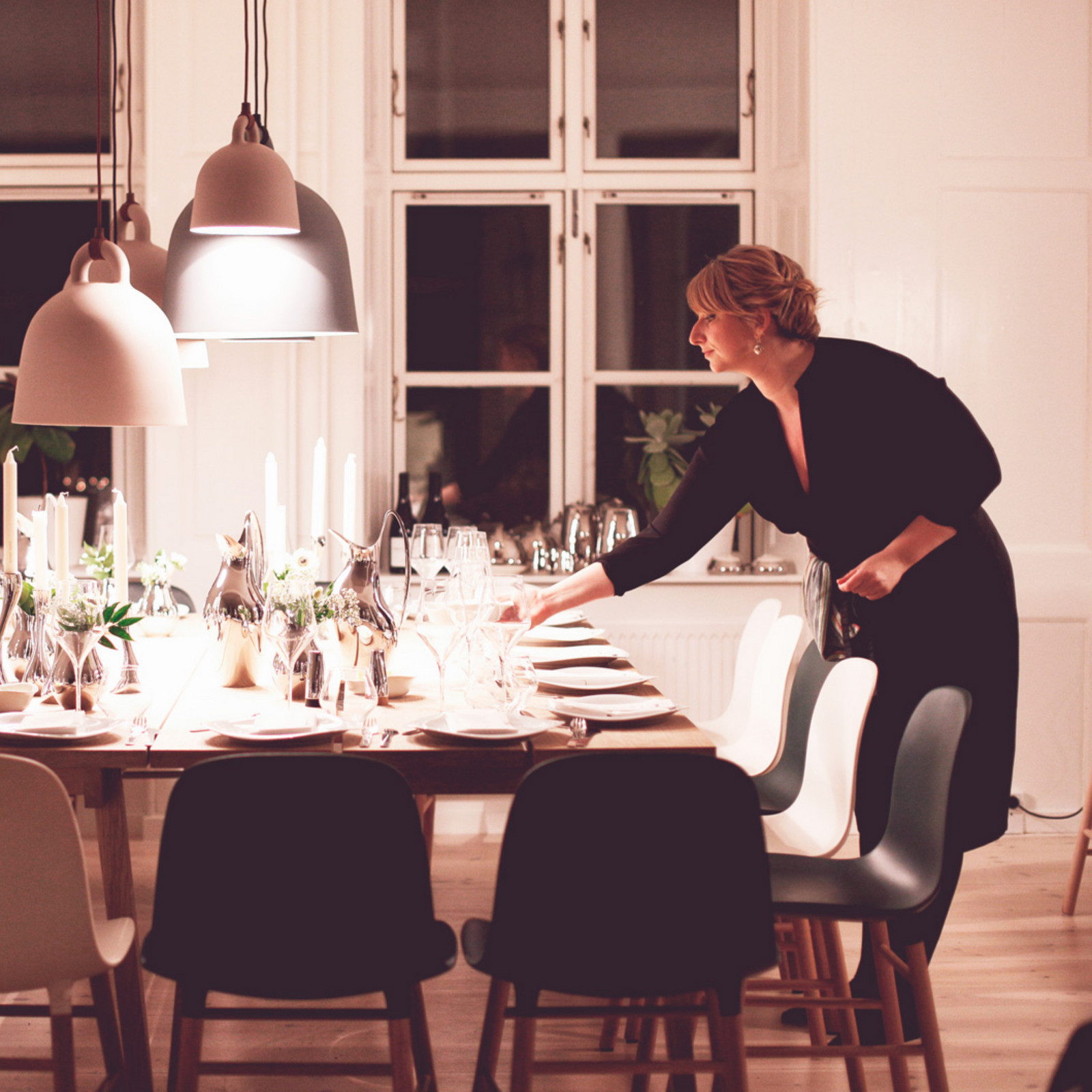 hochzwei_roba_teaser_03.jpg Frau im schwarzen Kleid deckt lange Tafel mit mehreren Stühlen