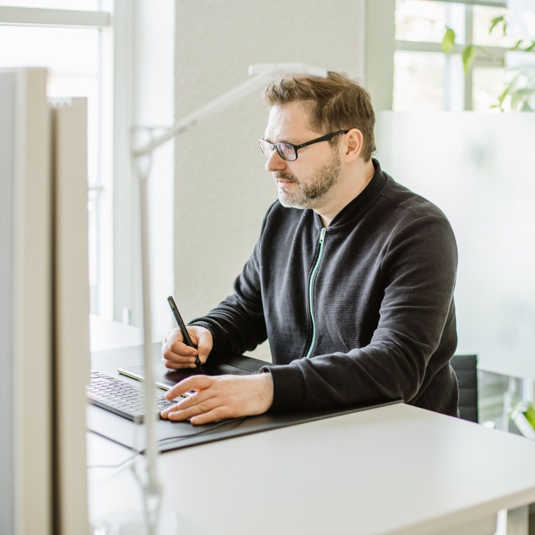 Unser Kollege Marcel Stender arbeitet konzentriert an seinem Schreibtisch.