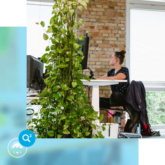 Onboarding HOCHZWEI-Mitarbeiterin sitzt an ihrem Schreibtisch