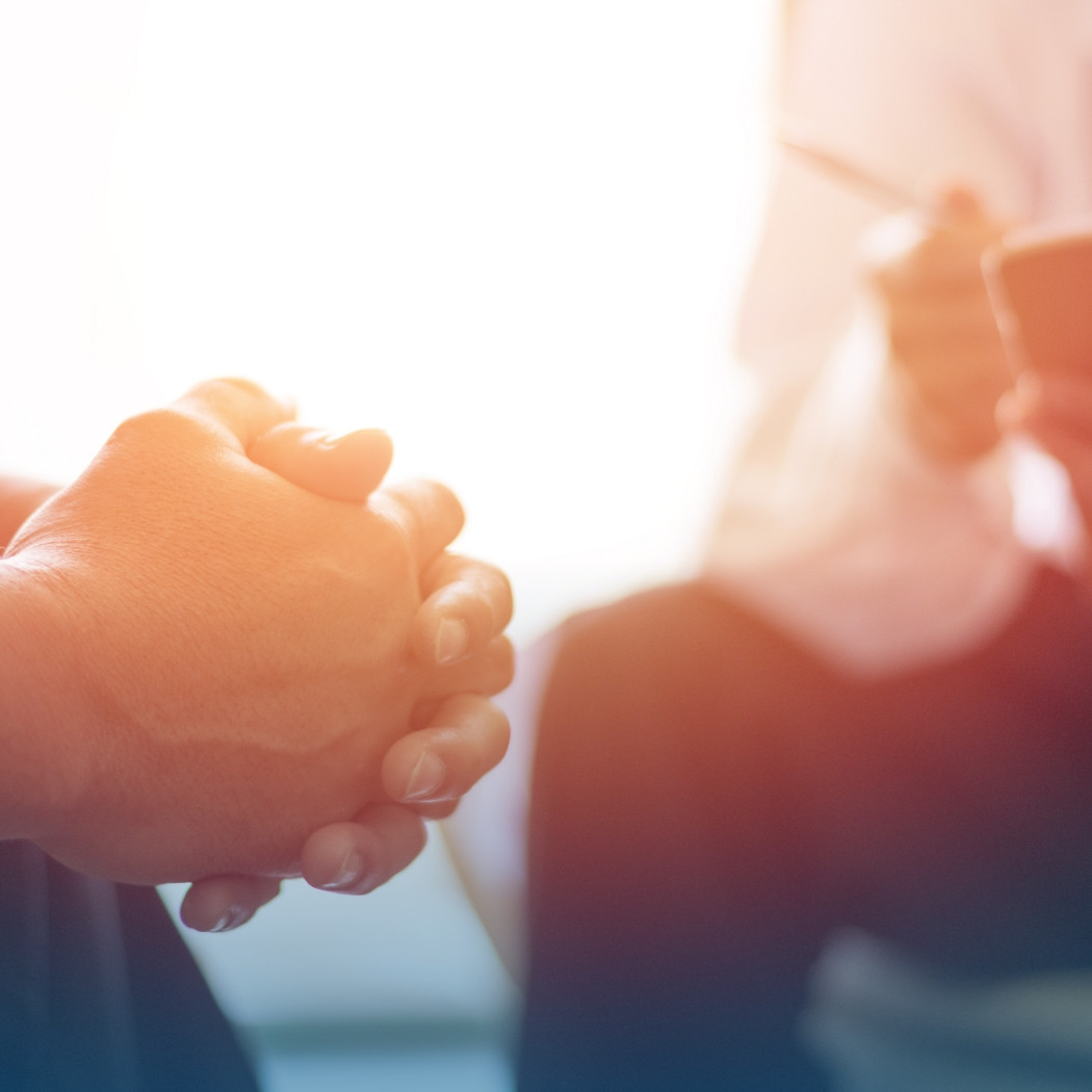 hochzwei_wksrecruiting_teaser_09.jpg Ein Mann sitzt mit verschränkten Händen