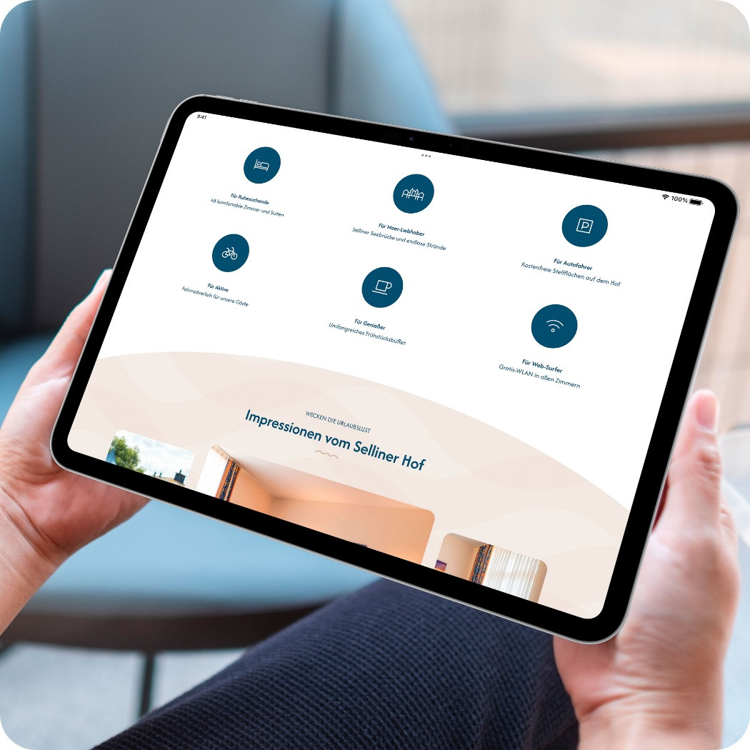Hände halten ein Tablet mit der Webseite