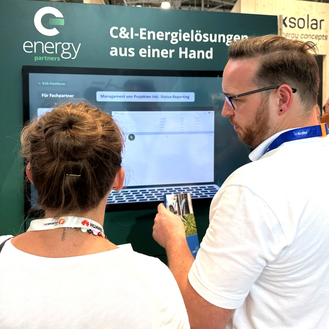 hochzwei_ENPAR_interaktives_Messetool_teaser_06.jpg Zwei Personen in weißen T-Shirts bedienen einen Bildschirm