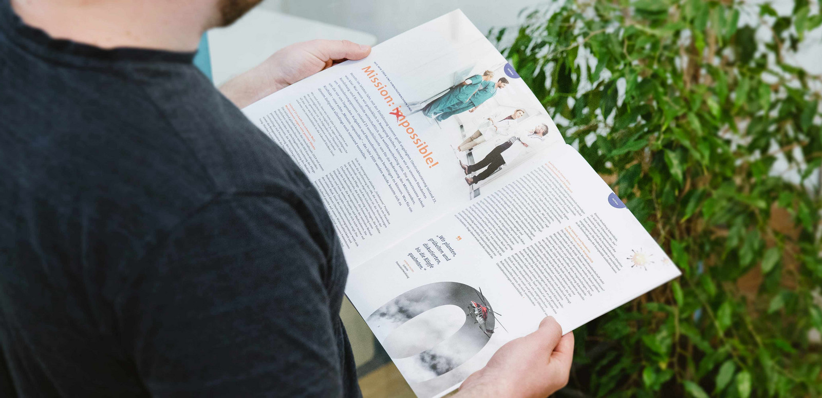 Mitarbeiter hält eine Zeitschrift in der Hand