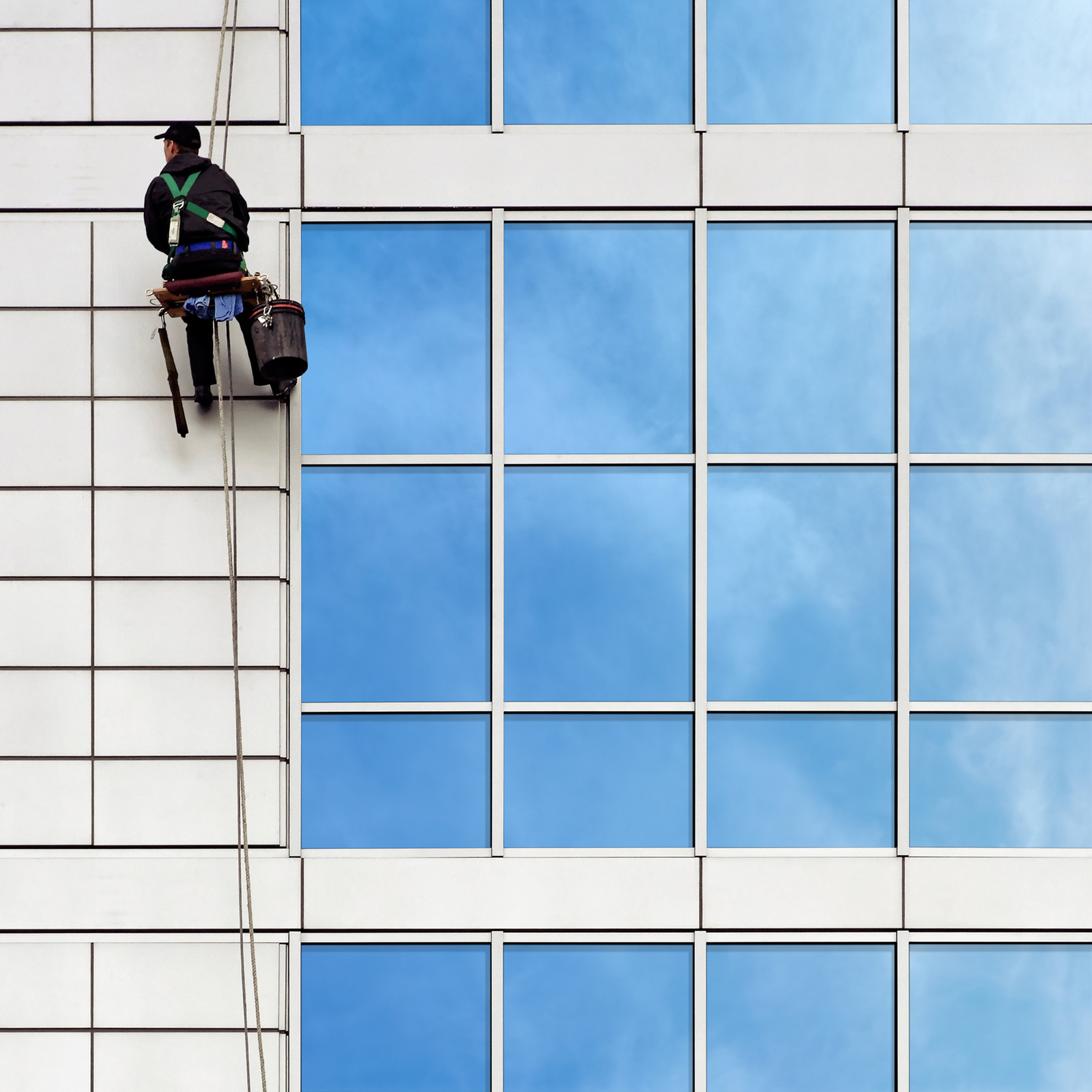Fensterputzer hängt an Fassade
