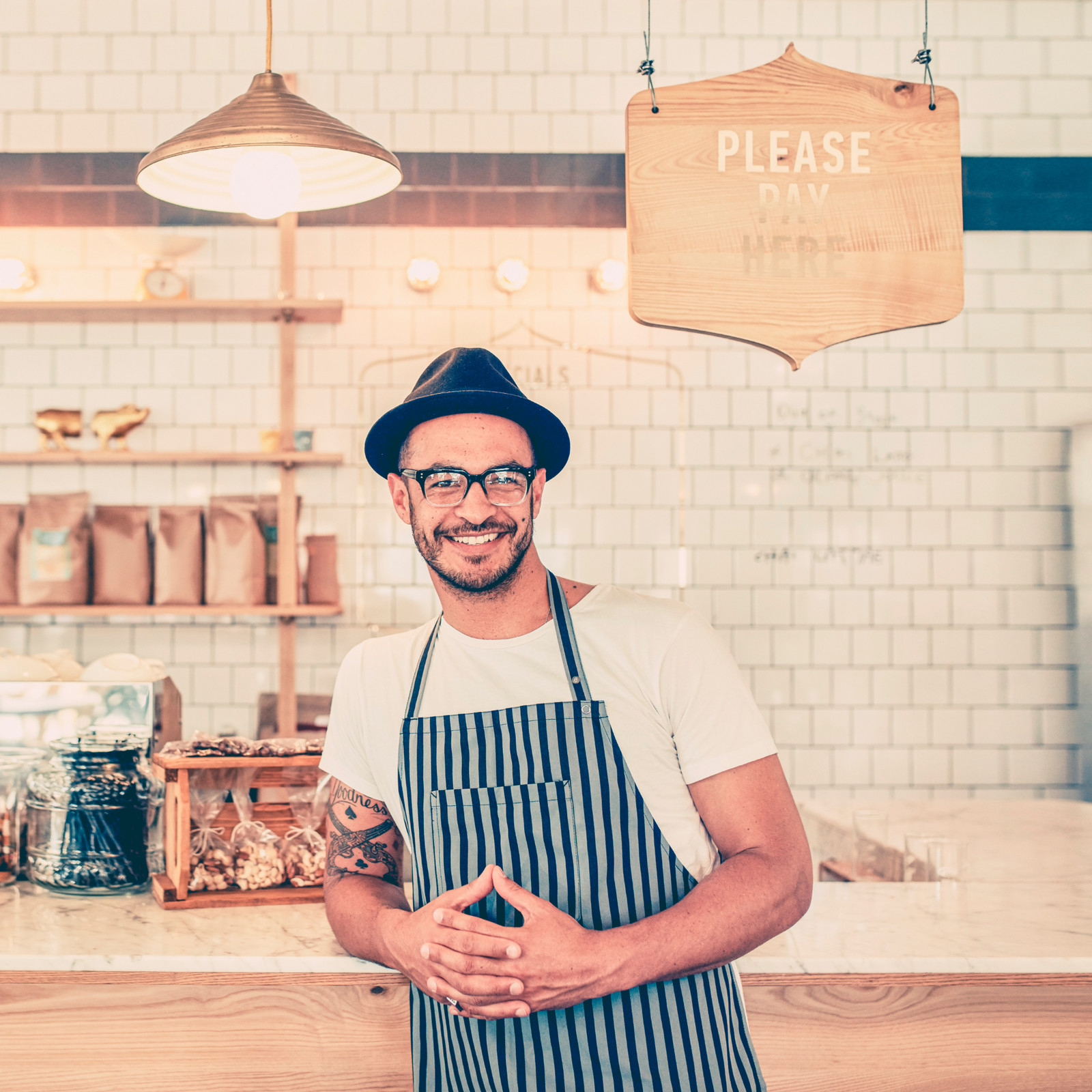 hochzwei_kien_teaser_03.jpg Mann mit einer gestreiften Schürze und einem schwarzen Hut lächelt in die Kamera