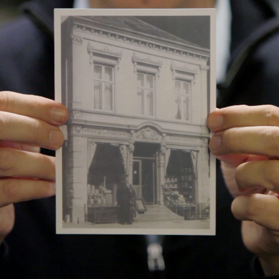 Zeitreise Eine Person hält ein schwarz weiß Foto in die Kamera