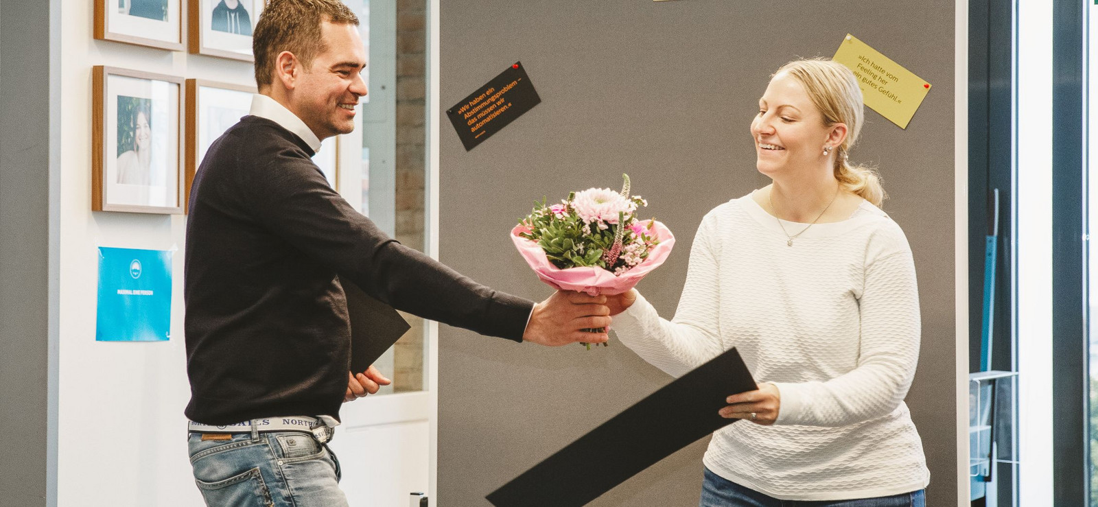 h2_Arbeitgeber_teaser_03.jpg Foto von Hochzwei Chef Felix Worm, der einer Hochzwei Angestellten einen Strauß Blumen überreicht. Sie freut sich sichtlich.