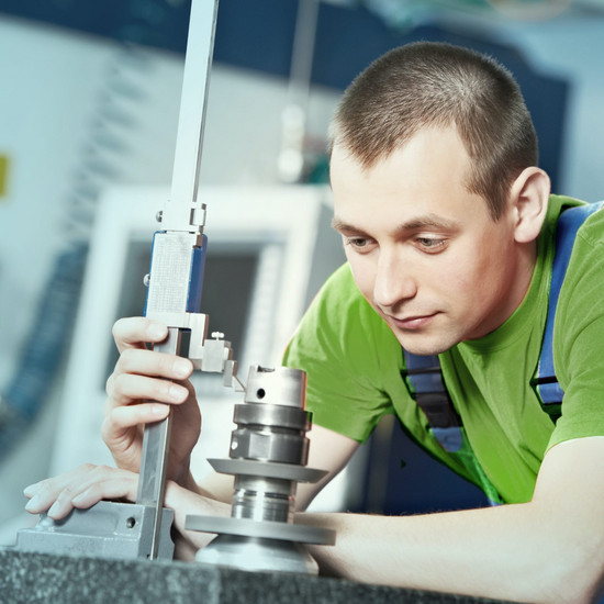 Getunt Mitarbeiter im grünen Shirt stellt eine Apparatur ein