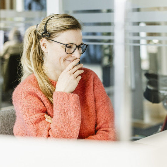 Interne Fortbildung bei HOCHZWEI Unsere Kollegin Regina Schmidt befindet sich in einem digitalen Meeting und sitzt schmunzelnd vor ihrem Bildschirm.