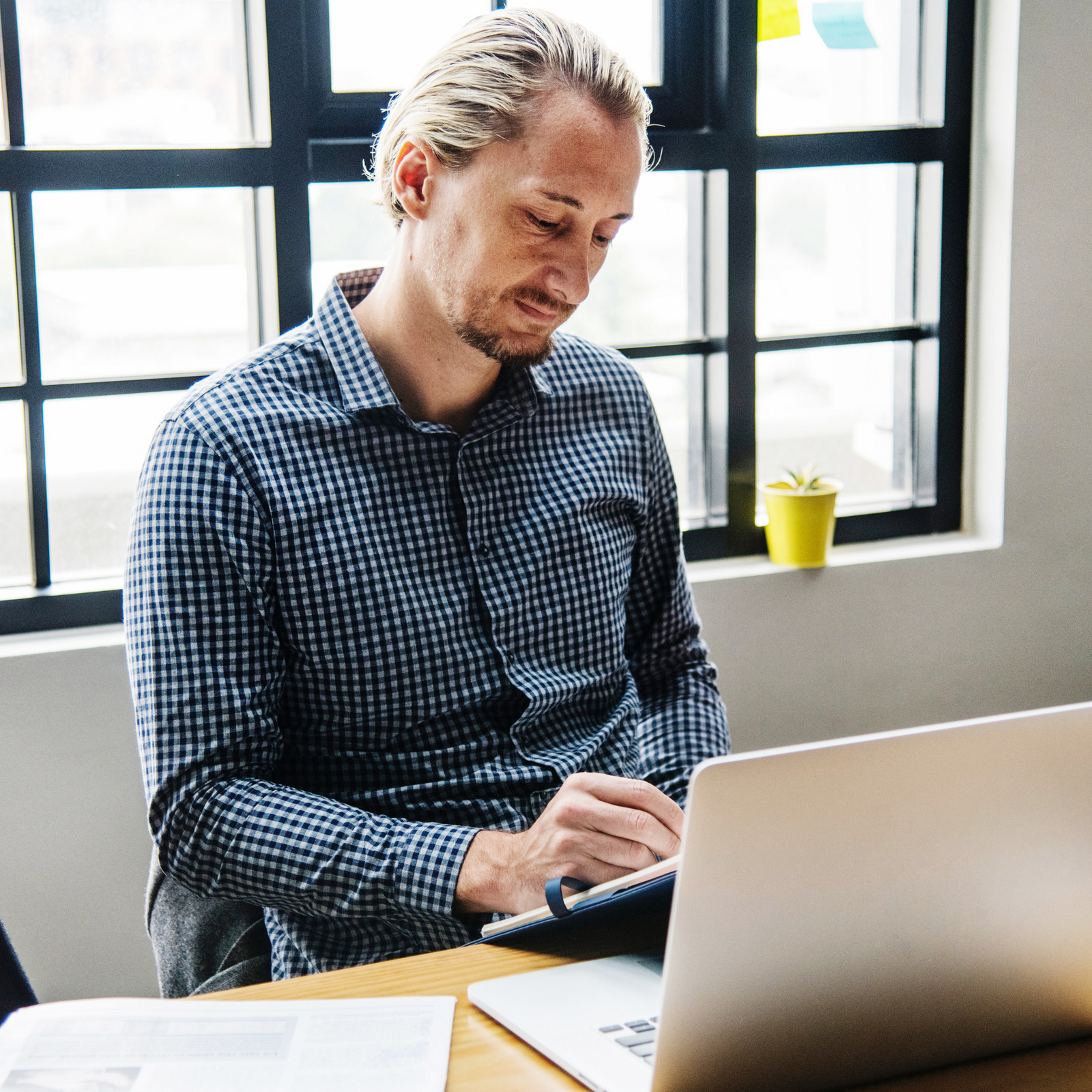 hochzwei_nade_teaser_03.jpg Blonder Mann im karierten Hemd bei der Arbeit