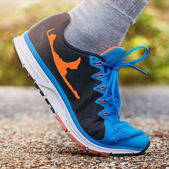 Insellösung Fuß im schwarz-blauen Turnschuh mit Syltlogo