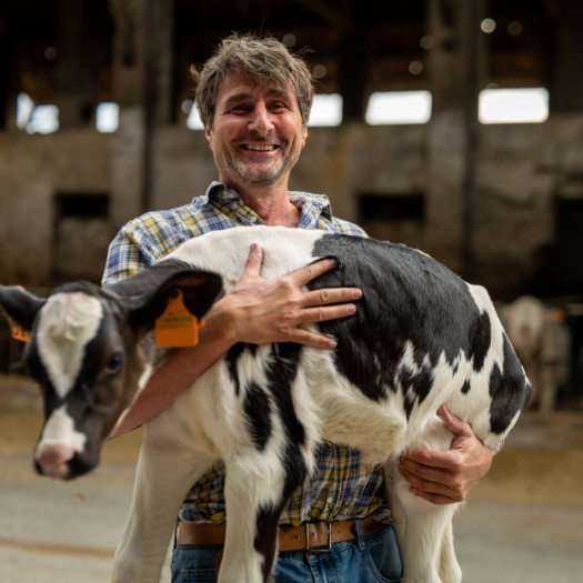 hochzwei_nospa_teaser_05.jpg Ein Bauer hält sein Kalb im Arm