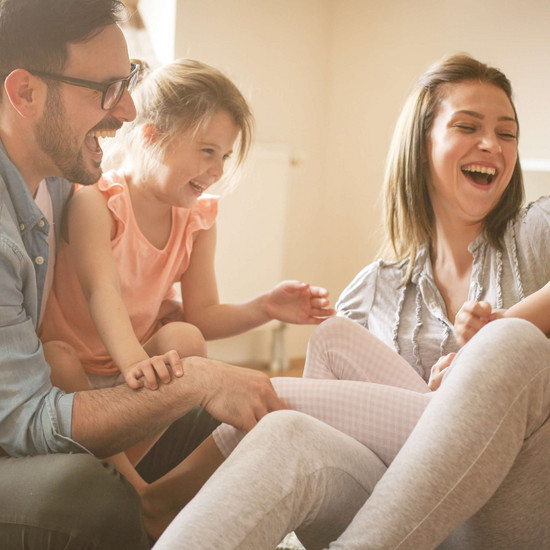 Neu errichtet Lachende Familie im Wohnzimmer